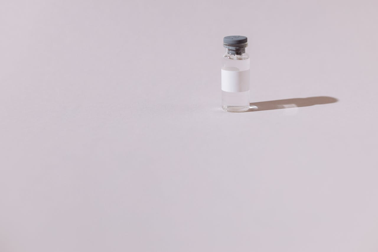A sterile vaccine vial isolated on a minimalist gray background, emphasizing health and medicine.